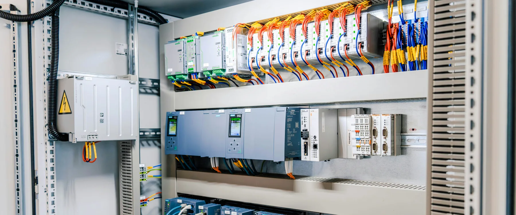 Cuadro de control industrial con cables identificados, módulos de control, variadores y bornes