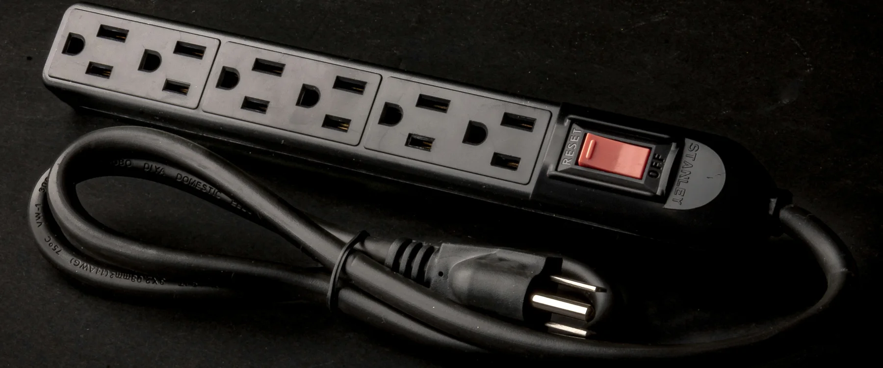 Six-outlet power strip with a red switch, coiled power cord and three-prong plug
