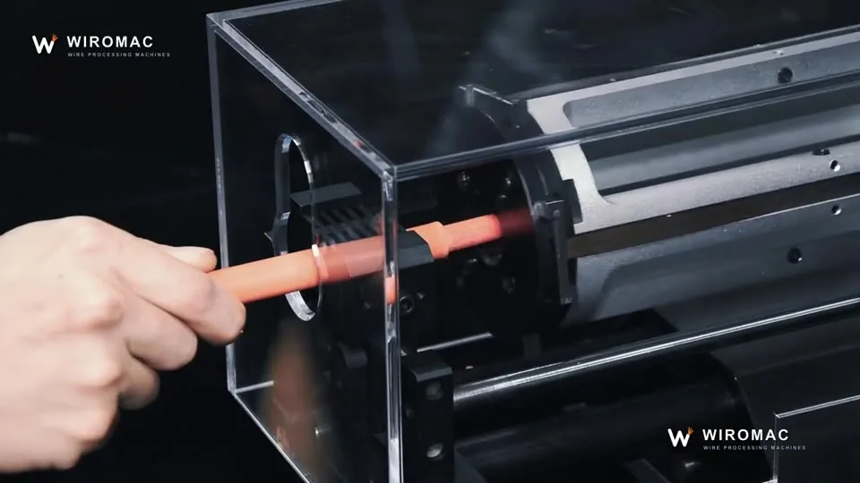 Charging-gun cable on a bench rotary head under a clear guard.