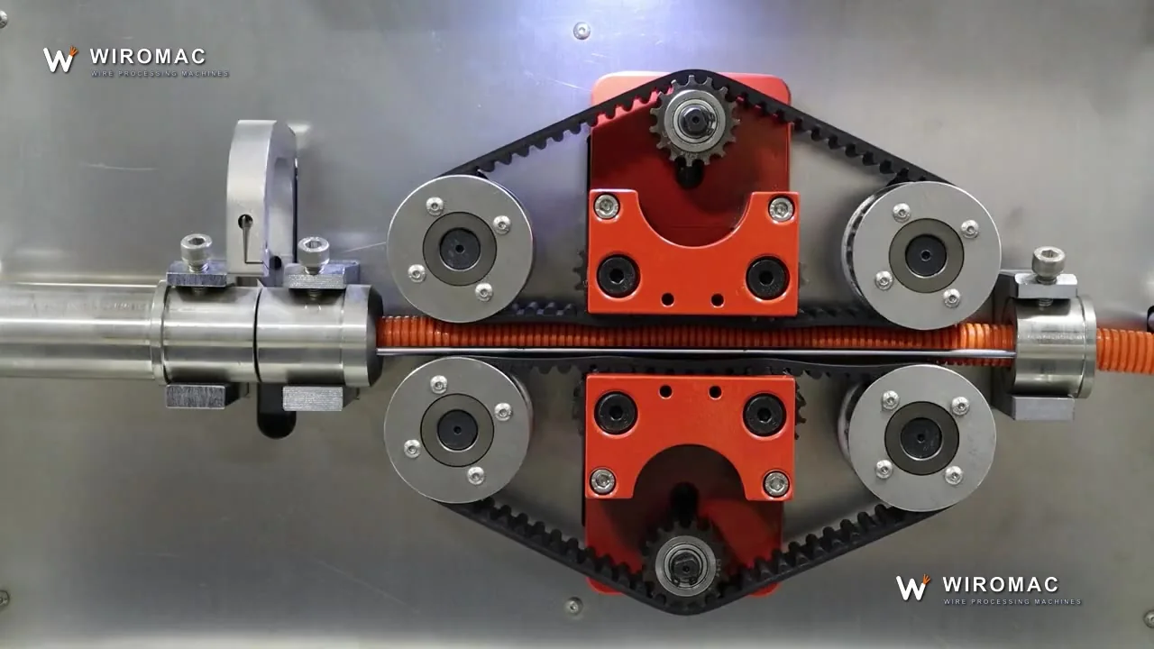 High-speed corrugated conduit cutting — feed wheels and blade under a clear guard.