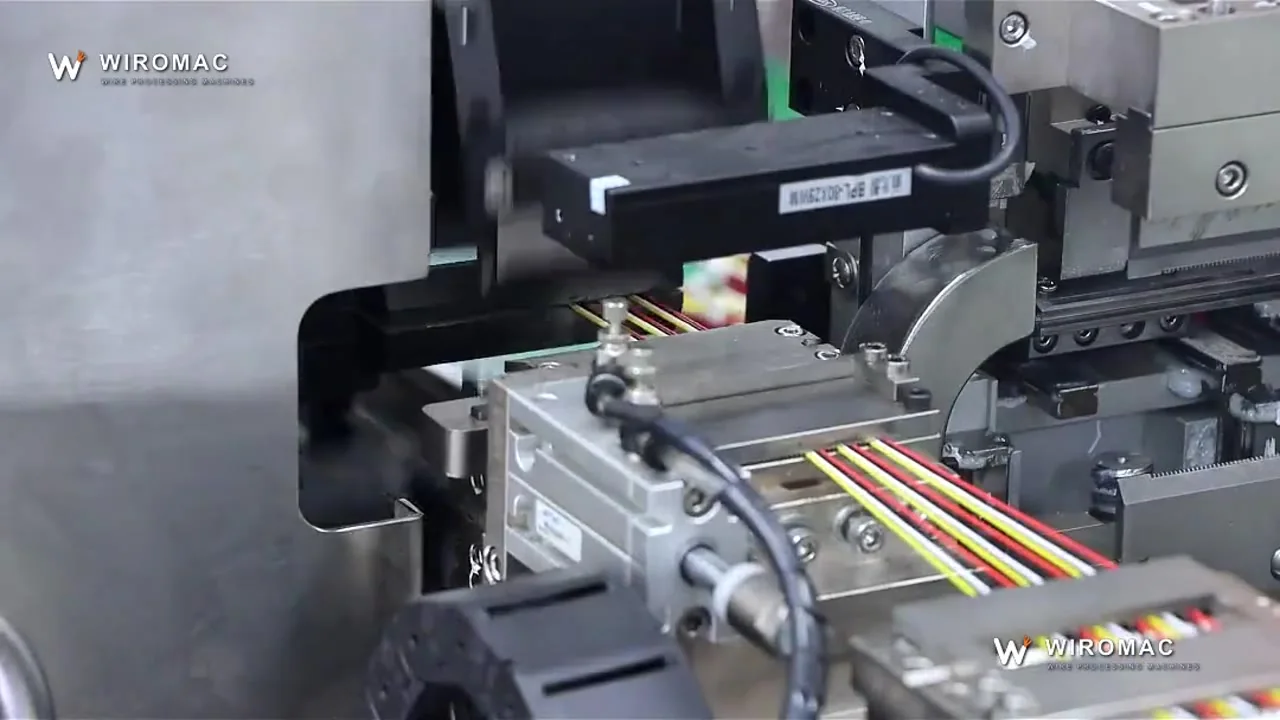 Crimped terminals pushed into a housing on the transfer belt — the lock engages before release.