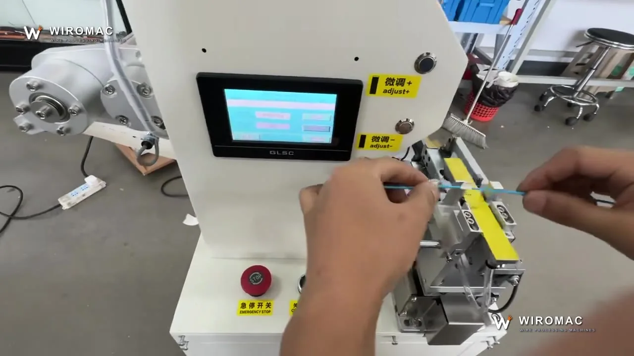Operator feeds a blue wire; the folding head applies white flag labels one after another.